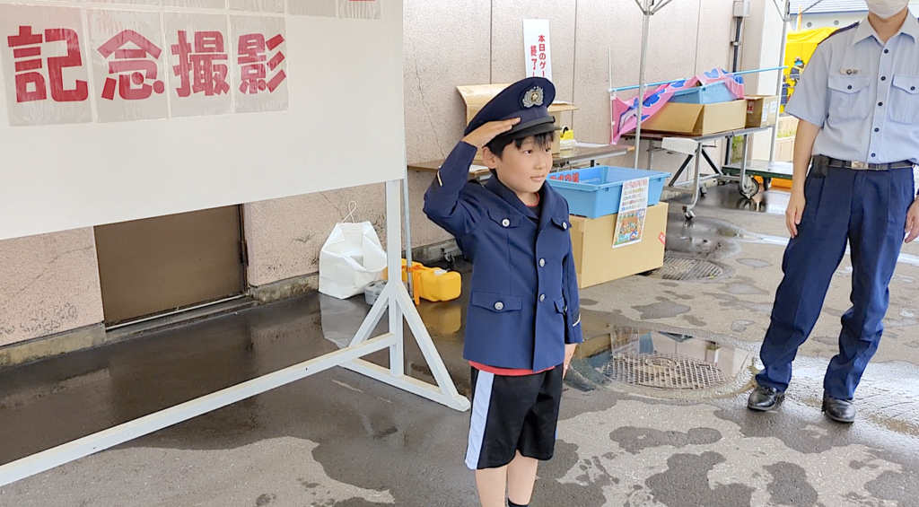 青森矯正で行われていた警察の体験ゾーンで制服を着て記念撮影する子ども