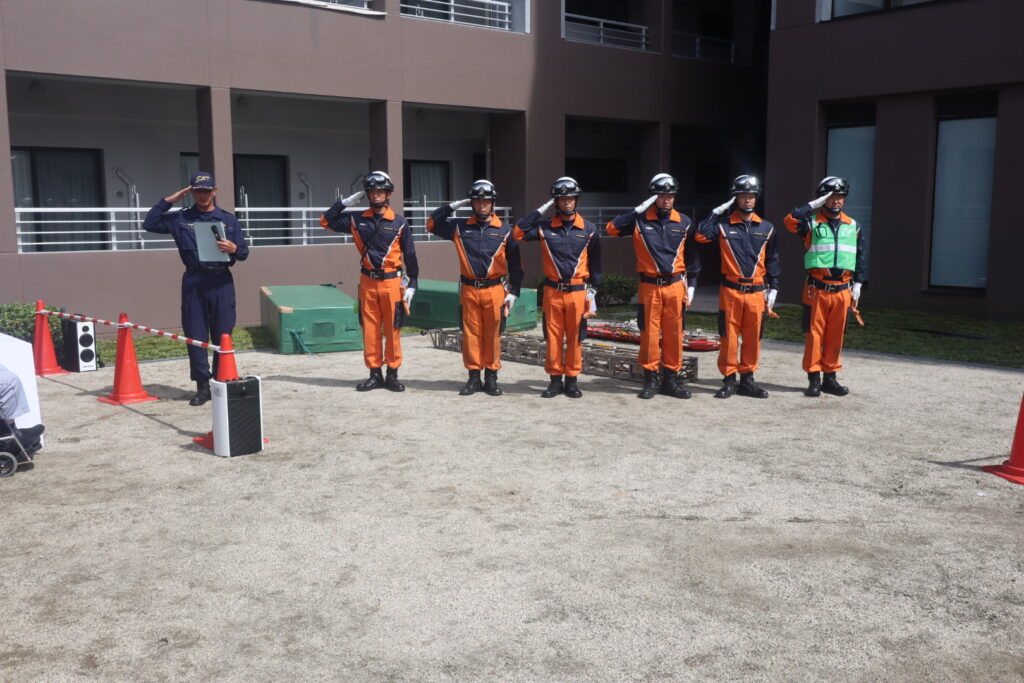 法務省矯正局特別機動警備隊による災害救助訓練実演で敬礼する隊員たち