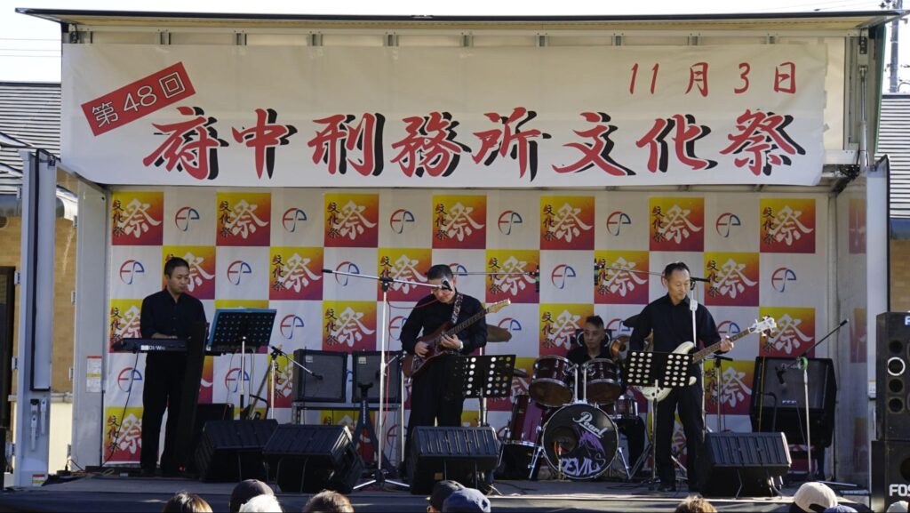 第48回府中刑務所文化祭（2023年開催）のメインステージで演奏するバンドメンバー
