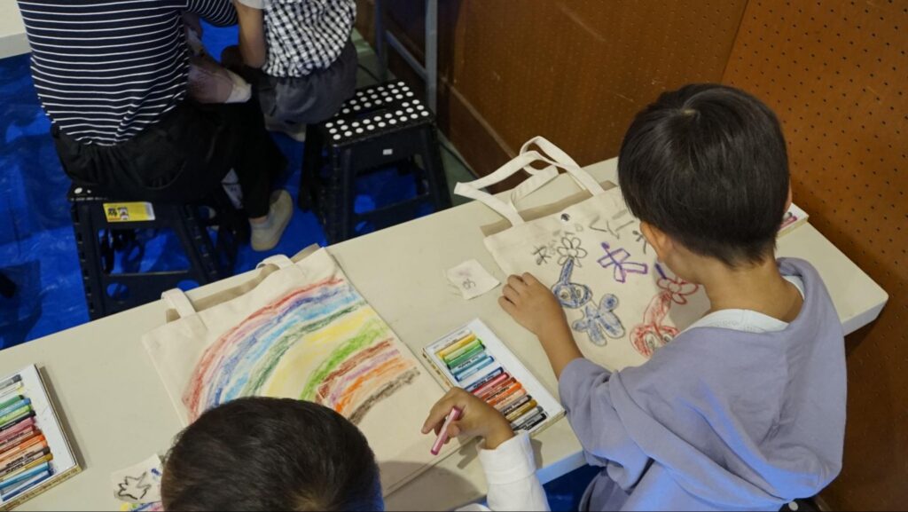 第48回府中刑務所文化祭（2023年開催）のトートバックのお絵描き体験コーナーでお絵描きを楽しむ子どもたち