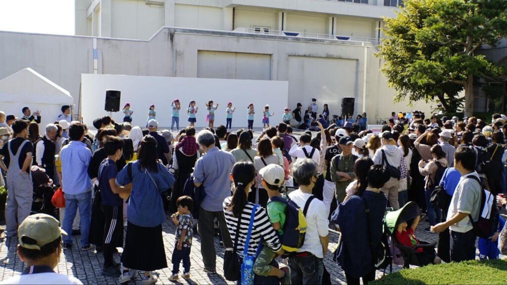 第51回横浜矯正展（2023年11月4日(土)@横浜刑務所）の会場に設営されているステージでダンスを踊る地域の子供たちと観客たち
