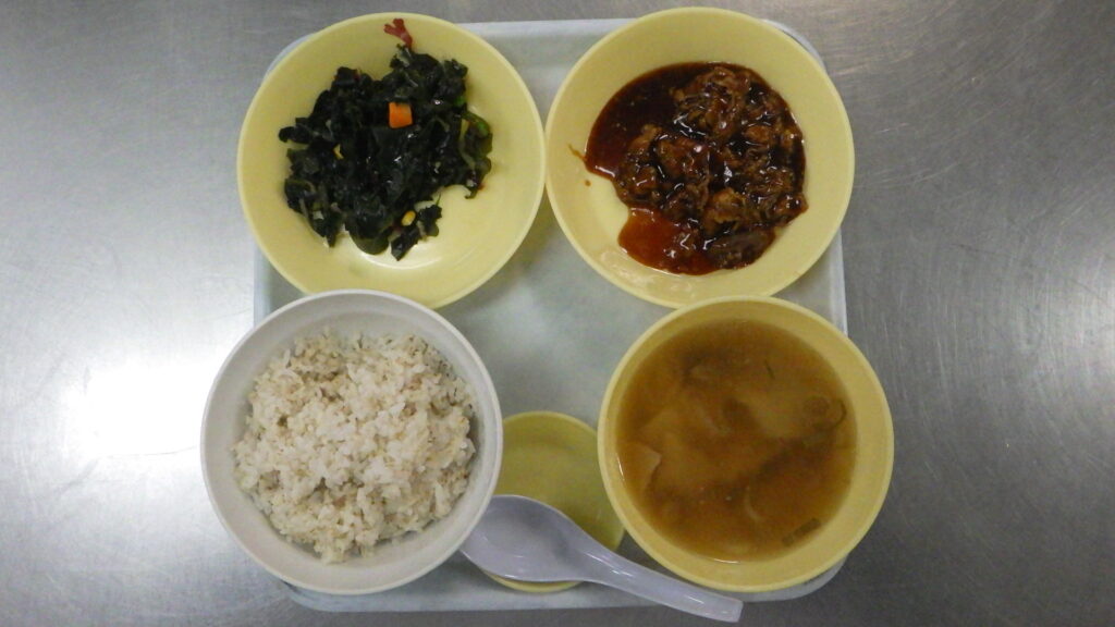 刑務所の食事（ムショ飯）の昼食：牛カルビ丼、海草サラダ、ワンタンスープ
