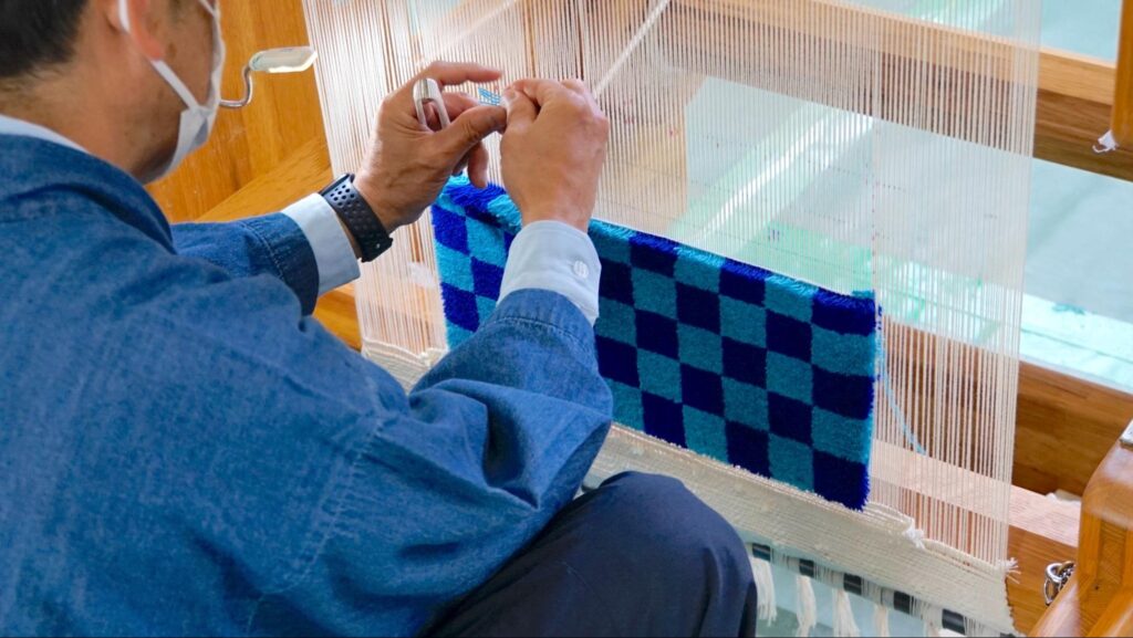 関西矯正展（2023年11月11日(土)、12日(日)開催）で刑務所作業製品作りを疑似体験できるブースで行われた伝統工芸の堺式手織緞通（さかいしきておりだんつう）の体験