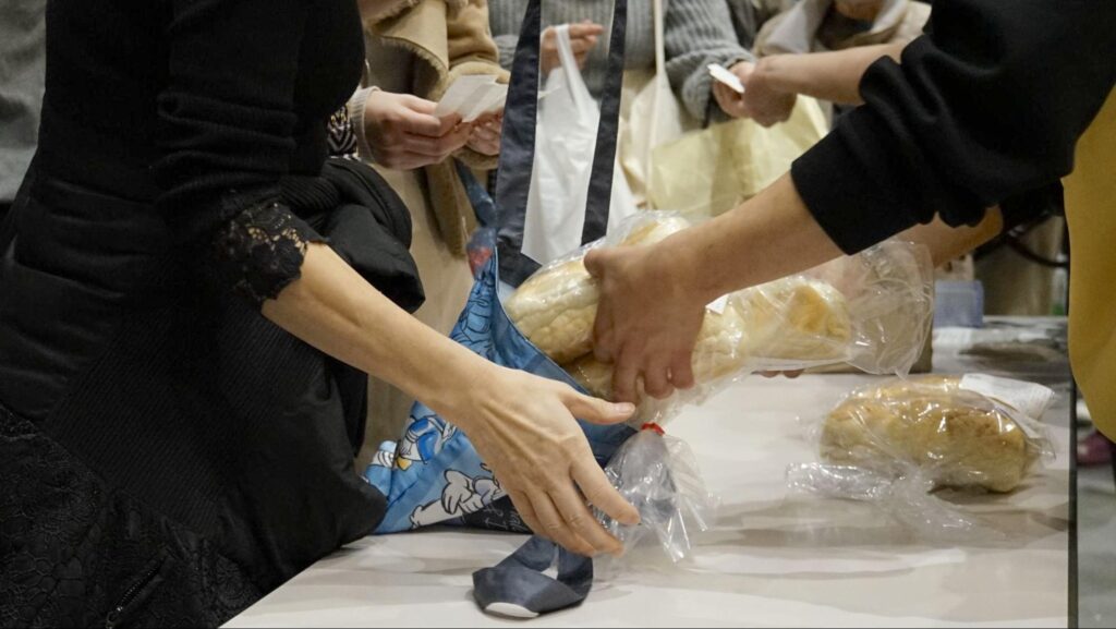全国矯正展（2023年12月9、10日開催）で販売された府中刑務所の刑務作業のコッペパンを購入する来場者たち