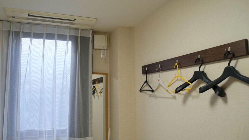 WILLER EXPRESS株式会社の東京営業所にある「新木場BASE」の宿泊棟にある宿泊部屋のハンガーと窓