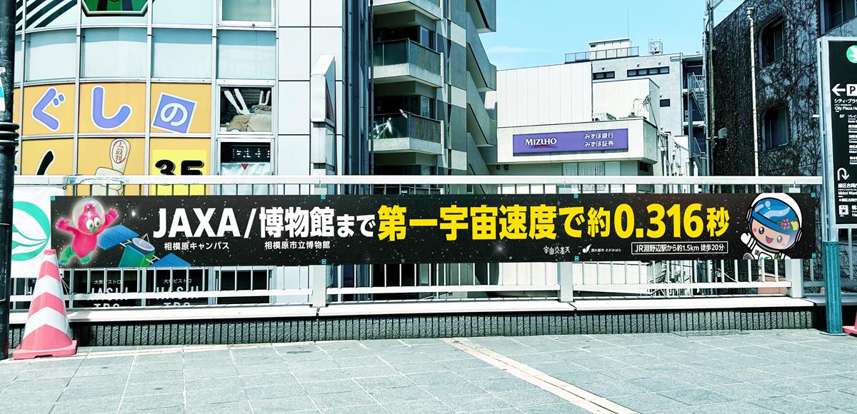 淵野辺駅および橋本駅から、JAXA相模原キャンパスと相模原市立博物館へ向かう導線上に設置された距離感を「宇宙スケール」で可視化した案内サインや横断幕