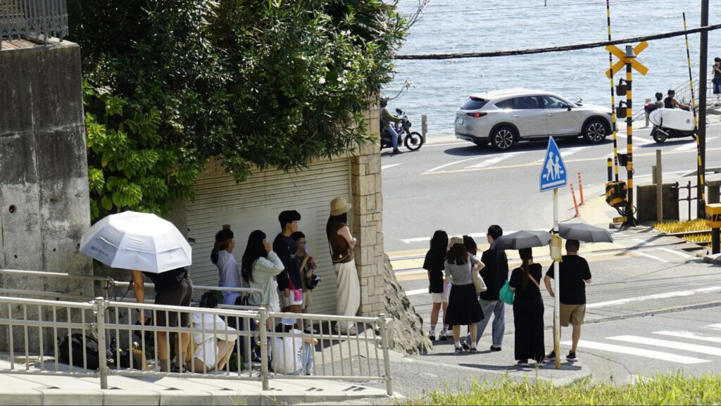 周辺住民の住宅の駐車場前に居座る外国人観光客もいた