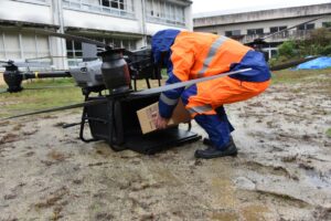 ドローンが到着し、消防団員により支援物資を取り出す様子 (2)