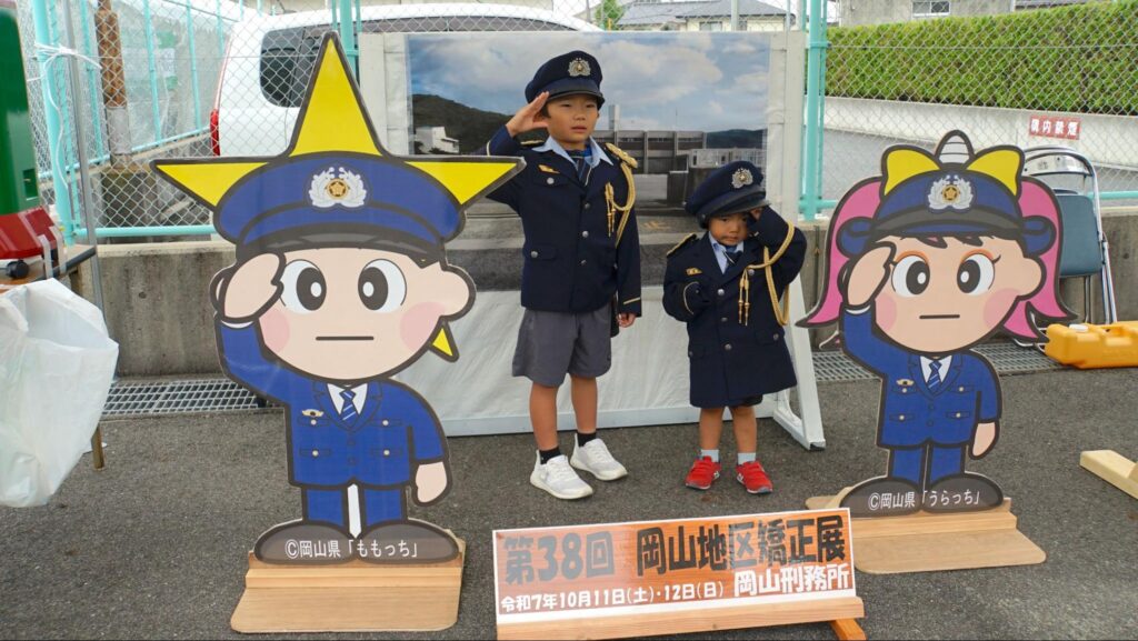 刑務官の制服を着て写真撮影をする子ども.