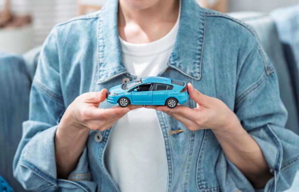 EVのミニカーを持つ男性