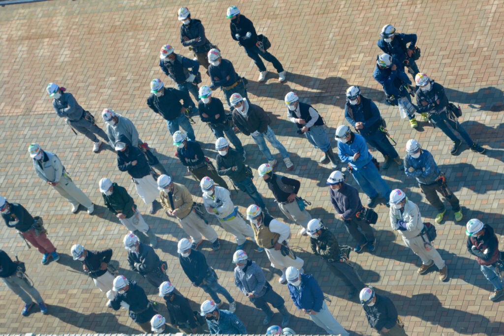 朝礼で集合する建設現場の技術者たち