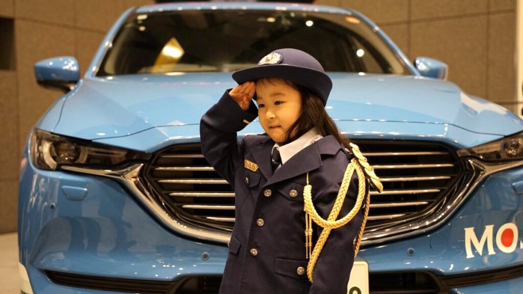 刑務官のキッズ制服を試着し敬礼する女の子