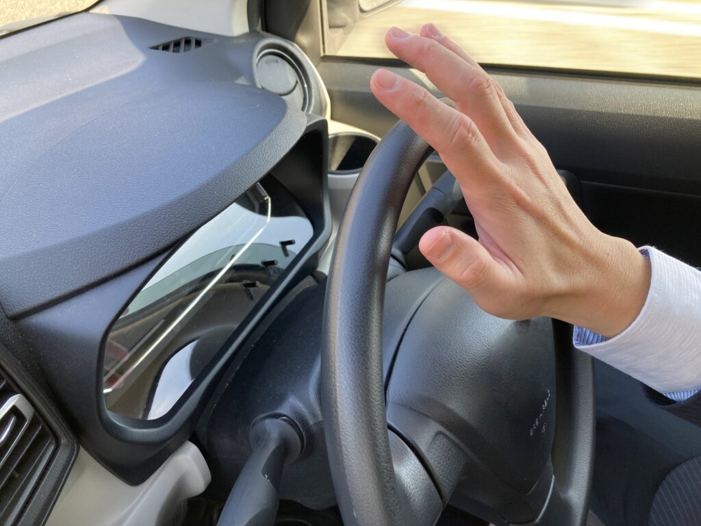 クラクションを鳴らす運転手の手