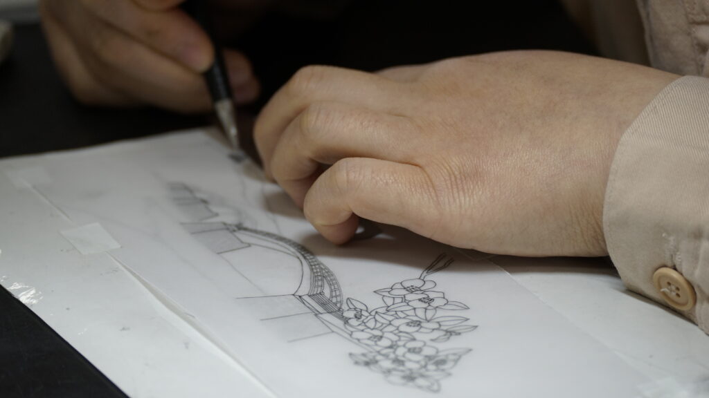 サンドブラスト作業でデザインを行う受刑者の手