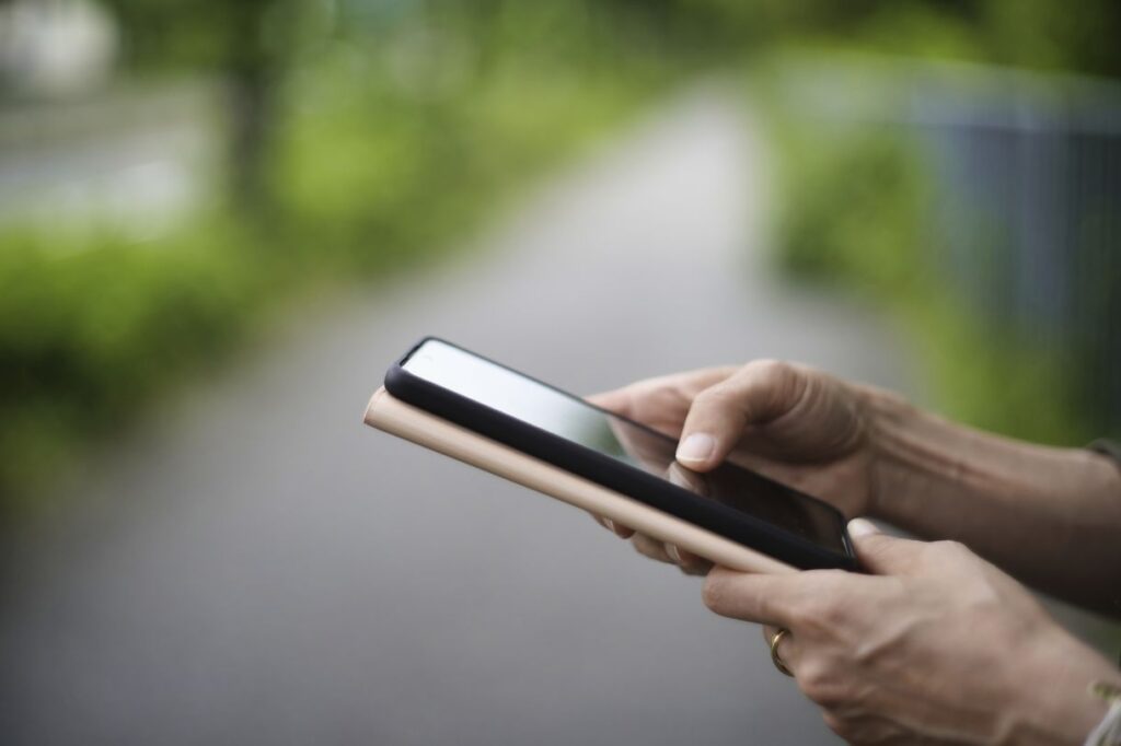 通報しようとスマートフォンを操作するする女性の手