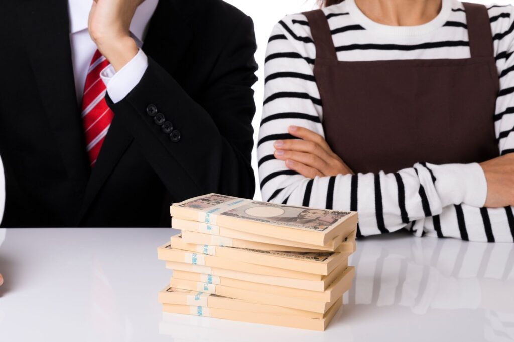 札束の前で悩む女性と男性