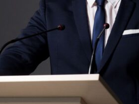 公聴会で釈明する男性