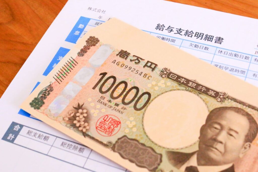 賃上げ後の給与明細と1万円札