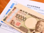 賃上げ後の給与明細と1万円札